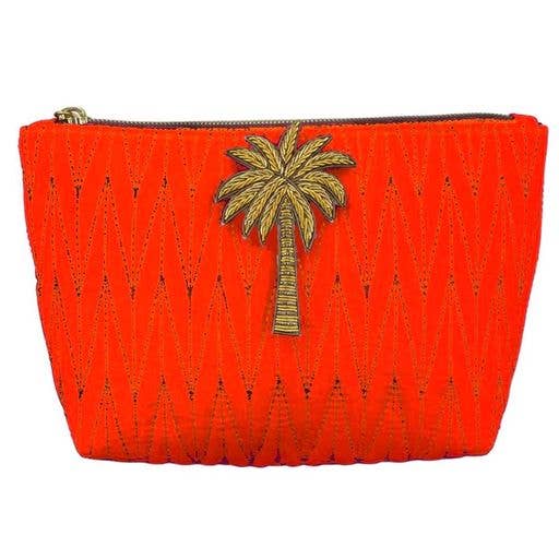 Bolsa de maquillaje Tribeca naranja con un alfiler dorado en forma de palmera